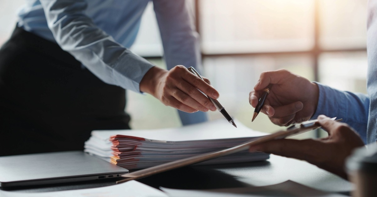 Homem aponta para uma lista de documentos para abrir mei